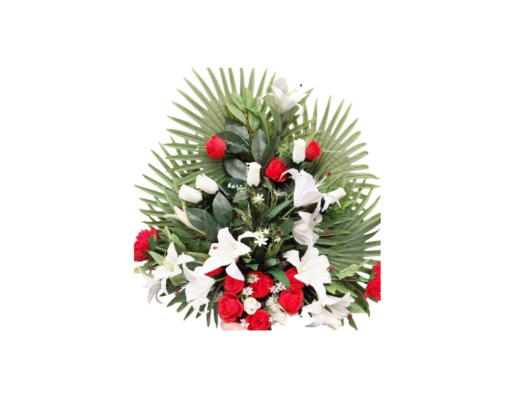 An elegant artificial floral arrangement designed around a structure of large palm leaves fanned out, combining roses in shades of red and white with delicate, highly realistic white lilies. Available for hire for events, advertising, films and TV series.
