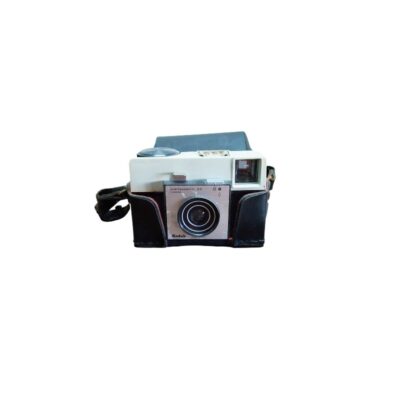 cámara fotográfica analógica compacta de la reconocida marca Kodak, modelo Instamatic 25, dotada de un cuerpo bicolor protegido en el interior de su funda de cuero sintético negro con correa alquiler para eventos, publicidad, peliculas y series