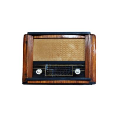 radio de época con caja de madera noble de líneas depuradas y elegantes molduras laterales texturizadas, caracterizada por un diseño clásico que combina una gran rejilla de tela superior para el altavoz y un panel frontal inferior oscuro que integra el dial sintonizador y mandos circulares contrastados alquiler para eventos, publicidad, peliculas y series
