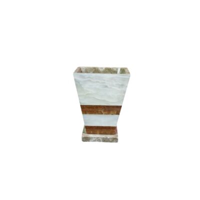 recipiente decorativo de época tallado en piedra natural de ónix, caracterizado por su forma troncocónica de líneas geométricas con franjas alternas en tonos claros y ámbar cálido, apoyado sobre una sólida base rectangular alquiler para eventos, publicidad, peliculas y series