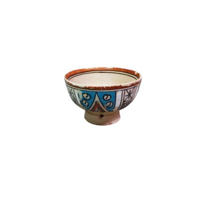 cuenco hondo de época elaborado en cerámica tradicional, caracterizado por su cuerpo semiesférico alzado sobre una peana cilíndrica distintiva y una llamativa decoración geométrica policromada a mano en tonos azules, blancos, marrones y negros alquiler para eventos, publicidad, peliculas y series