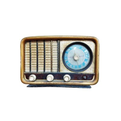 radio de época con mueble de madera de líneas redondeadas, caracterizada por un diseño clásico que combina una rejilla metálica texturizada para el altavoz en el lado izquierdo y un prominente dial de sintonización circular con aguja en el lado derecho, complementado con mandos de control frontales alquiler para eventos, publicidad, peliculas y series