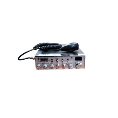 emisora de radio CB (Citizens Band) de época, caracterizada por su carcasa metálica rectangular con un panel frontal cromado que integra múltiples mandos giratorios, interruptores de palanca y un vúmetro analógico, acompañada por su correspondiente micrófono de mano con cable en espiral alquiler para eventos, publicidad, peliculas y series